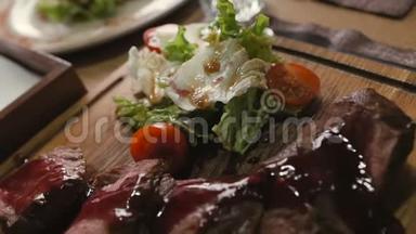 餐厅桌子上放着生菜和樱桃番茄的牛排